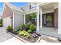 Close-up of the home's entrance, showcasing landscaping and a welcoming front porch with chairs at 8635 Nolan Dr, Fishers, IN 46038