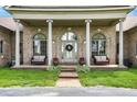 Covered front porch featuring white columns, seating, and decorative plants and wreath at 893 W 500 S, Anderson, IN 46013