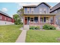 Charming two-story home with a welcoming front porch, brick accents, and well-manicured lawn at 1009 Broadway St, Indianapolis, IN 46202