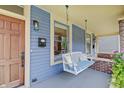 Inviting front porch features a comfortable porch swing, a secure mailbox, and classic wood door at 1009 Broadway St, Indianapolis, IN 46202