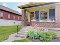 Inviting front porch with brick pillars, flower accents and a cozy porch swing at 1009 Broadway St, Indianapolis, IN 46202