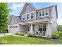 Beautiful two-story home with a brick facade, covered porch, and green lawn at 10993 Liberation Trce, Noblesville, IN 46060