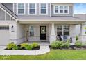 Inviting front porch with cozy seating and well-maintained landscaping at 10993 Liberation Trce, Noblesville, IN 46060
