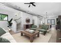 Open-concept living room with stairs, modern furnishings, and an abundance of natural light at 1100 English Ave, Indianapolis, IN 46203