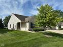 View of a single-story home with a well-maintained lawn and mature tree at 11711 Whisper Cove Dr, Fishers, IN 46037