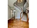 A grand foyer with hardwood floors and a staircase featuring white railings and wood trim at 12044 Bird Key Blvd, Fishers, IN 46037