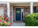 Inviting front door with wreath, beautiful flowers, and classic brick facade at 12331 Chiseled Stone Dr, Fishers, IN 46037
