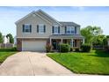 Attractive two-story home featuring a well-kept lawn, attached garage, and welcoming entrance at 12331 Chiseled Stone Dr, Fishers, IN 46037