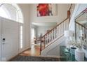 Bright foyer featuring wood floors, staircase, and an open view to the living room at 13244 Snow Owl Dr, Carmel, IN 46033