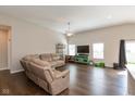 Spacious living room features hardwood floors, a ceiling fan, and large windows for lots of natural light at 1483 Paper Birch Dr, Sheridan, IN 46069