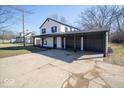 Two-story home with black trim, a long driveway and an attached two car garage at 1808 Raible Ave, Anderson, IN 46011