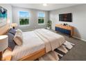 Bright main bedroom featuring large windows, a ceiling fan, and stylish furnishings at 18230 Sandy Cove Ln, Westfield, IN 46074