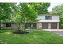 Charming two-story home featuring a stone facade and a well-maintained front yard with mature trees at 2120 Wynnedale Rd, Indianapolis, IN 46228