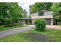 Charming two-story home with stone facade, two-car garage, and mature landscaping at 2120 Wynnedale Rd, Indianapolis, IN 46228