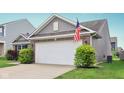 Two-car garage with vinyl siding, brick accents, and an American flag at 2911 W Hawanian Ln, Monrovia, IN 46157