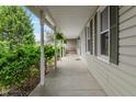 Inviting covered porch featuring a bench and lush landscaping surrounding the home at 3631 S 450 E, Whitestown, IN 46075