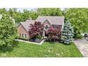 Beautiful brick home with mature trees and a well-manicured lawn overlooking a serene pond at 3708 Gould Dr, Carmel, IN 46033