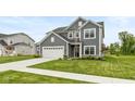 A charming two-story home with gray siding, a white garage door, and a well-maintained lawn at 3980 Railhead Ave, Westfield, IN 46074