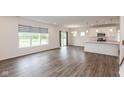 Open-concept living room featuring hardwood floors, large windows, and access to the kitchen at 3980 Railhead Ave, Westfield, IN 46074