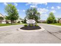 The Springs at Saratoga condominium community sign on an island with mature trees and landscaping at 4261 Washington Blvd, Plainfield, IN 46168