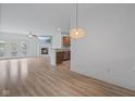 Open concept living room with hardwood flooring, fireplace, ceiling fan, and view of the kitchen at 4261 Washington Blvd, Plainfield, IN 46168