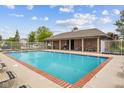 Community pool with red brick trim, white metal fence, covered patio with tables and chairs at 4261 Washington Blvd, Plainfield, IN 46168