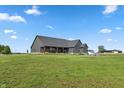 Rear exterior view of home with a large yard and covered porch at 4457 E County Road 850 N, Pittsboro, IN 46167