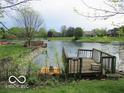Scenic waterfront view with a wooden dock and lush greenery at 4667 Sundance Trl, Indianapolis, IN 46239