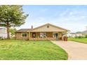 Cozy one-story home featuring a stone exterior, inviting front porch, and a green lawn at 521 Sunset Dr, Edinburgh, IN 46124