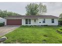 Inviting single-story home with vinyl siding, attached garage, and a neat front yard with green grass at 5416 Straw Hat Dr, Indianapolis, IN 46237