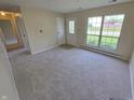 Bright living room with neutral carpet, a large window, and a front door with decorative glass at 5416 Straw Hat Dr, Indianapolis, IN 46237