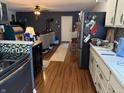 View from kitchen to living room with wood floors and dark painted brick wall with fireplace at 5585 Gallagher Dr, Greenwood, IN 46142