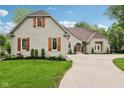 Beautiful exterior view of home showcasing the brick facade, wooden shutters, and well-manicured lawn at 5786 E Fall Creek Pkwy N Dr, Indianapolis, IN 46226