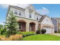 Beautiful two-story home featuring stone and brick accents, a welcoming entryway, and lush landscaping at 6078 Hardwick Dr, Whitestown, IN 46075