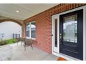 Inviting front porch with brick accents, seating area, and a stylish front door at 6078 Hardwick Dr, Whitestown, IN 46075