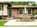 Exterior patio area featuring a dining table with chairs, an umbrella, and brick accents at 6126 Rucker Rd, Indianapolis, IN 46220