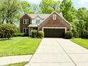 Charming two-story brick and siding home with an attached garage, on a lush lawn at 6242 Carrington Dr, Indianapolis, IN 46236