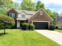 Traditional two-story home with brick and vinyl siding, attached garage, and landscaped front yard at 6242 Carrington Dr, Indianapolis, IN 46236