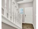 Bright entryway with white railings, wood floors, a front door, and a window at 6463 Wasco Dr, Whitestown, IN 46075