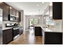 Modern kitchen featuring stainless steel appliances, granite countertops, and dark wood cabinets at 6463 Wasco Dr, Whitestown, IN 46075