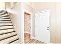 Bright entryway features wood floors, stairs with black accents, and a front door with decorative glass detailing at 6471 Hunters Green Pl, Indianapolis, IN 46278