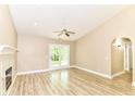 Bright living room features a vaulted ceiling, fireplace, ceiling fan, and French doors leading to a patio at 6471 Hunters Green Pl, Indianapolis, IN 46278