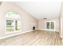 Spacious living room featuring a vaulted ceiling, large windows, a fireplace, and access to the outdoors at 6471 Hunters Green Pl, Indianapolis, IN 46278