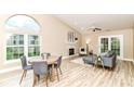 Open-concept living room with vaulted ceilings, fireplace, and dining area with large windows at 6471 Hunters Green Pl, Indianapolis, IN 46278