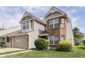 Attractive two-story home with a brick and vinyl exterior, an attached garage, and neatly trimmed bushes at 6542 E Edna Mills Dr, Camby, IN 46113