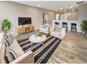 An inviting living room featuring modern furniture, sleek barstools, and hardwood floors at 6847 Cardiff Dr, McCordsville, IN 46055