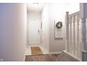 Inviting entryway featuring neutral tones, decorative wreath, and staircase access enhancing the home's welcoming ambiance at 8317 Pine Branch Ln, Indianapolis, IN 46234