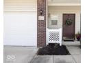 View of the front entrance featuring a maroon door with a decorative wreath and a white fence at 8317 Pine Branch Ln, Indianapolis, IN 46234