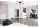 Open concept living room with grey flooring, ceiling fan, bar seating and view to kitchen at 8317 Pine Branch Ln, Indianapolis, IN 46234