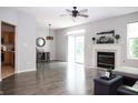 Spacious living room boasts a fireplace, modern light fixture, sliding glass door access, and wood flooring at 8317 Pine Branch Ln, Indianapolis, IN 46234